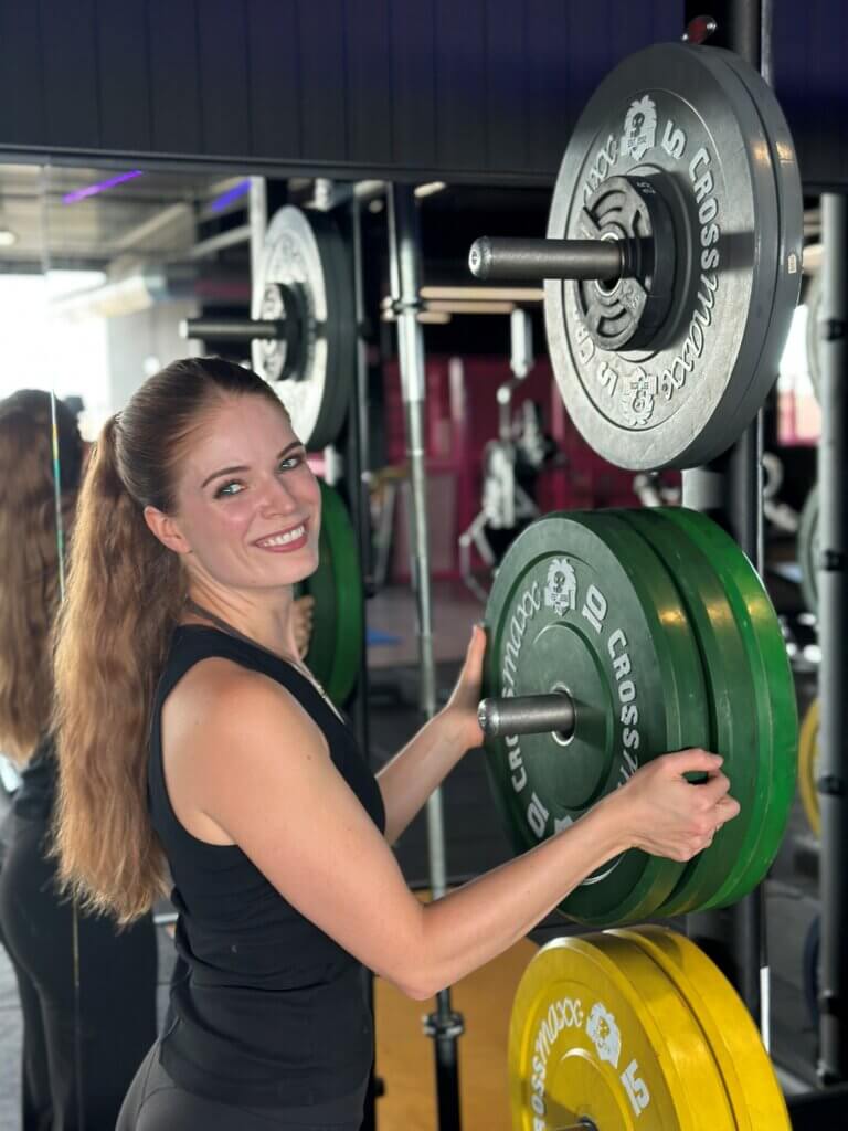 Sportdiëtiste Jamie van der Zanden in de fitness met halterschijven