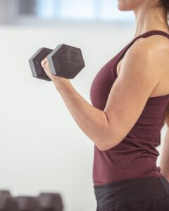 Vrouw die krachttraining doet met een dumbbell